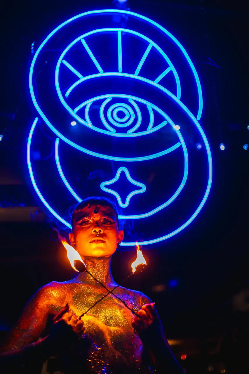 Performer com pintura corporal e instalação de neon